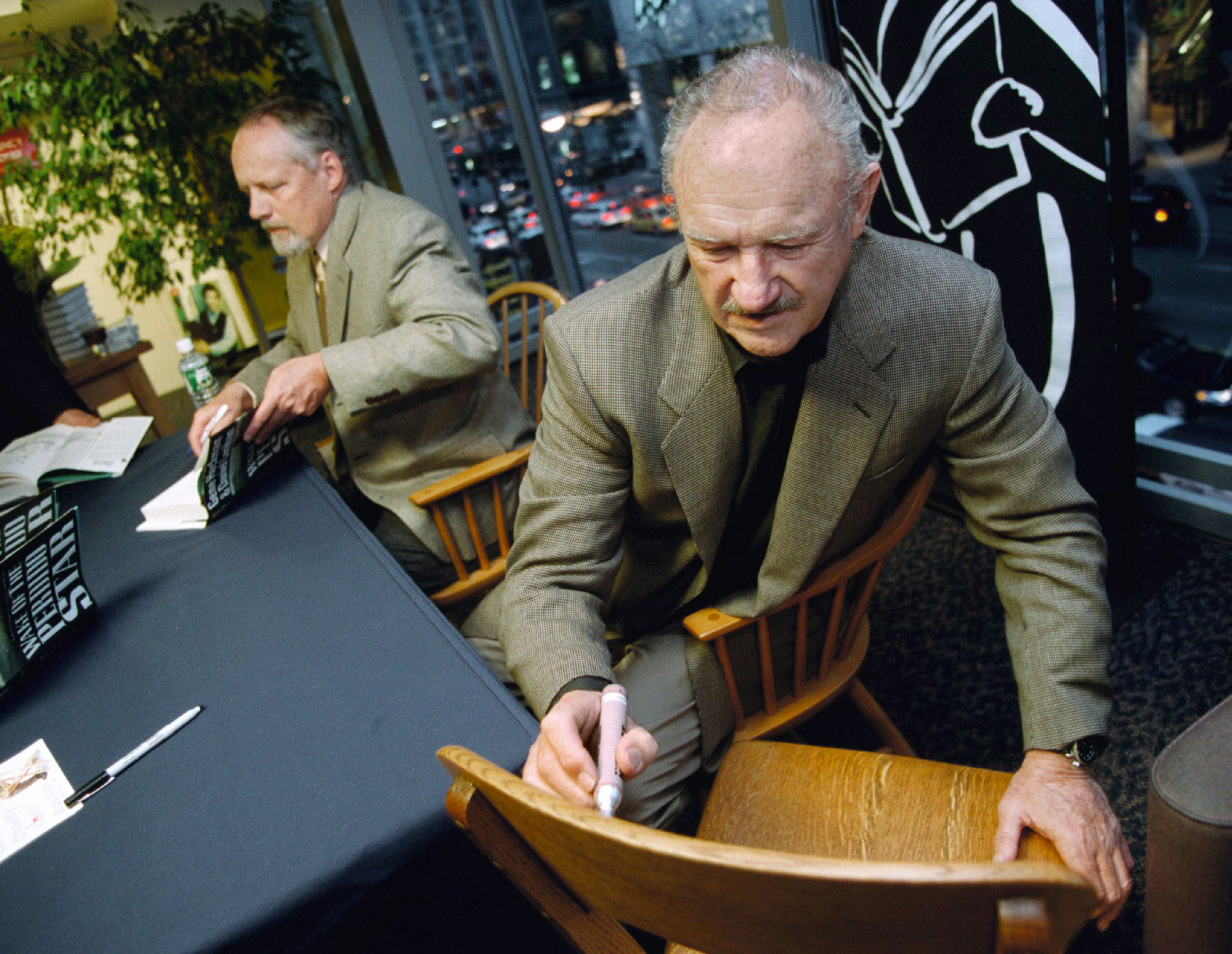 Gene Hackman signs a chair for a fan while also signing posters from his movie "The French Connection" at a Borders book store in Chicago, on April 28, 2000 | Source: Getty Images