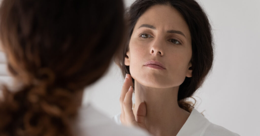 Close up woman looks in mirror touch face feels upset detects mimic wrinkles or pigment spots