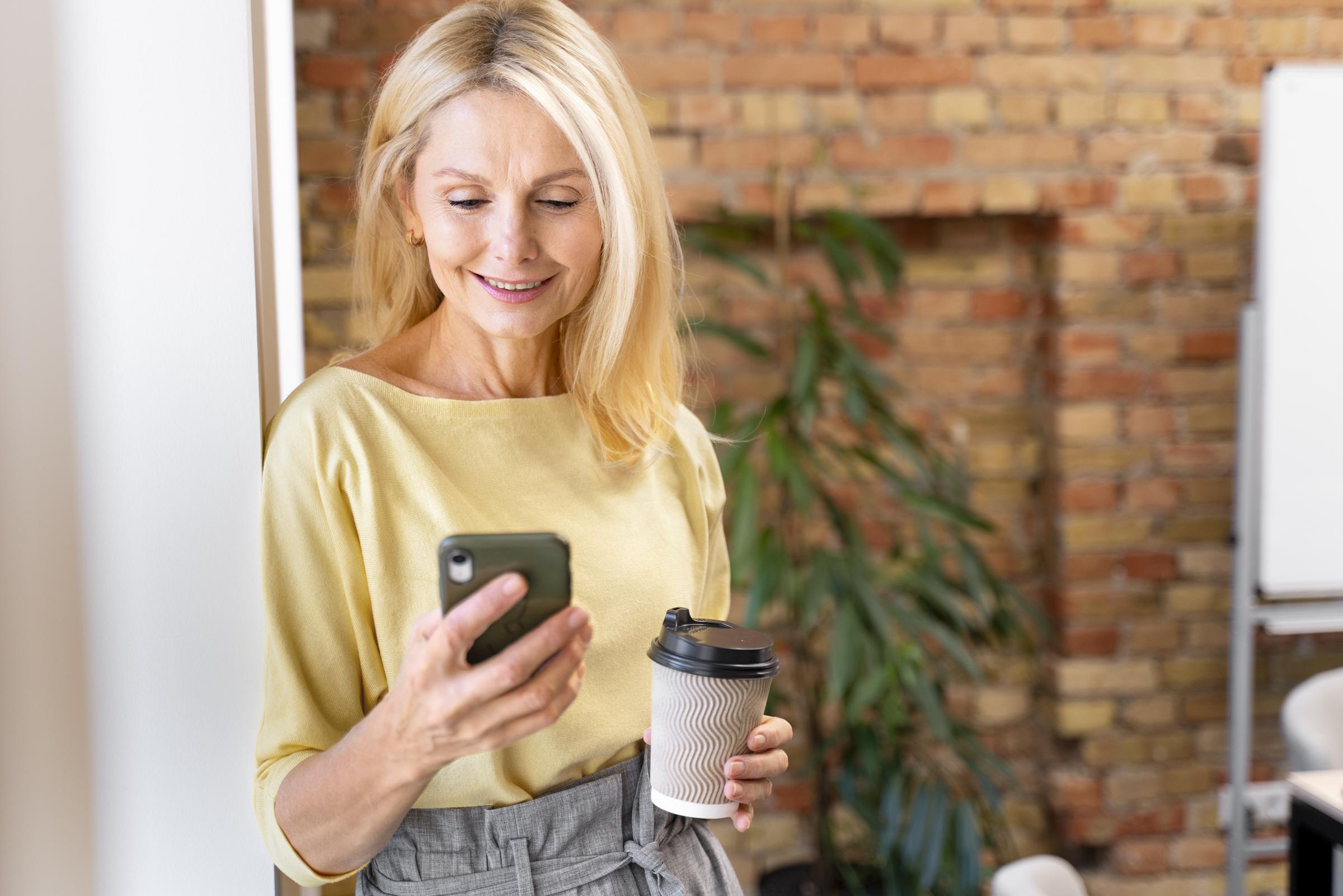 A smiling woman on her phone | Source: Freepik